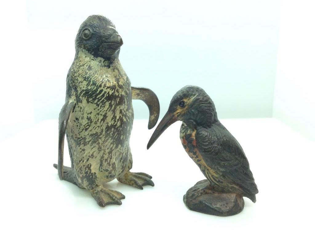 Lot 2 metal bird Figurals, penguin and Kingfisher: Dark toned metal, with painted details, some wear to paint, Penguin Measures approx 3 in by 2 in. Kingfisher measures approx 2 in by 1 1/2 in by 1 in. Decorative arts and accessories, tableware, table