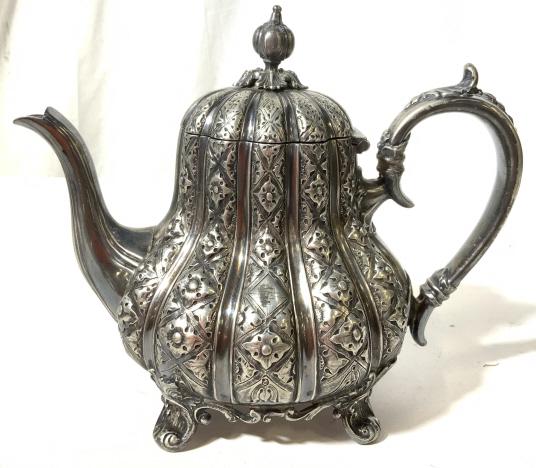 THOMAS OTLEY Silver Plated Tea Pot. ENGLAND: This piece is a silver plated tea kettle from THOMAS OTLEY. The underside reads 2075 THOMAS OTLEY SHEFFIELD. The piece is intricately detailed, some of the detailing has worn through age and use. The 