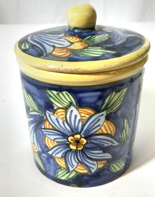 ARMENANTE VIETRI Glazed Earthenware jar, Italy: This piece is a glazed earthenware urn. The piece is hand painted and depicts several flowers on a cobalt blue base, the rim of the jar, and lid are painted a powder yellow, the handle is a powder yel