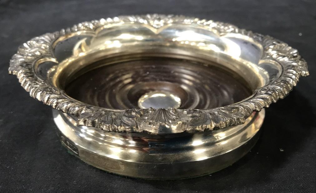 Silver Toned Metal Wine Coaster: Wine coaster is silver toned & Metal. Piece has trademark on side. Piece measures approximately 6.5 inches wide 1.5 inches tall. Coaster, wine coaster, tabletop accessories. barware 6