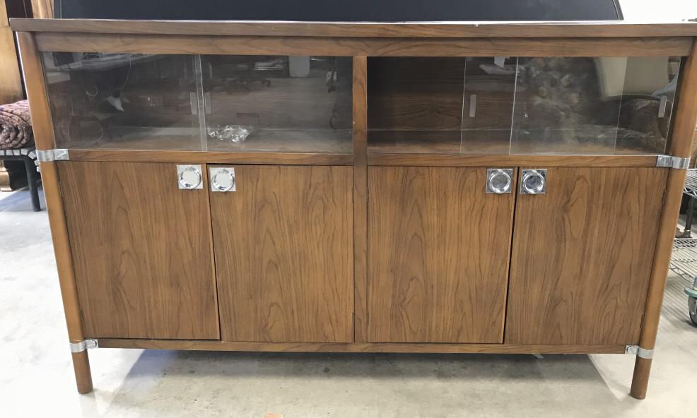 MCM Wooden Console W Sliding Glass Doors: Console has sliding glass doors on top half. Lower half has 2 set of cabinet doors . One cabinet area has drawer. Cabinet doors have chrome handles. Piece also has other chrome accent details. Console
