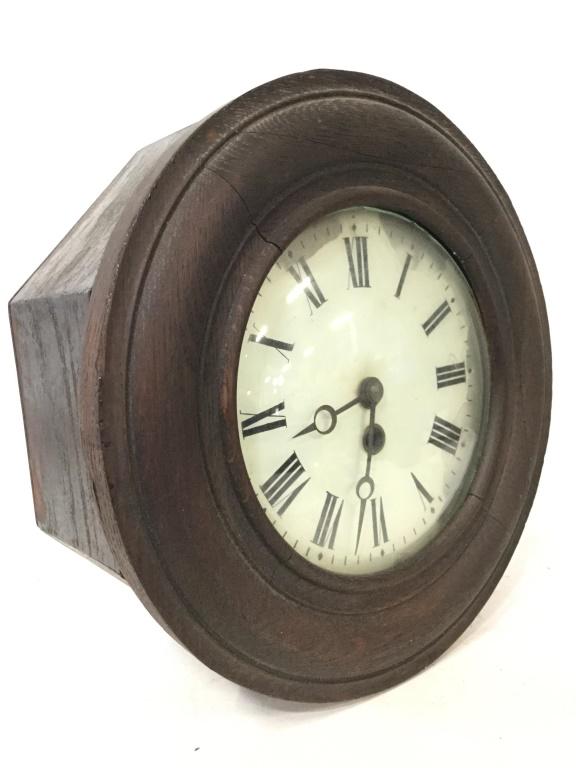Vintage Carved Wooden Wall Clock: Wall Clock is wooden. Front of piece is round. Piece has white toned clockface with black toned Roman numerals. Piece measures approx 11.5 inches diameter. Piece opens up to clockface,. Piece has evid