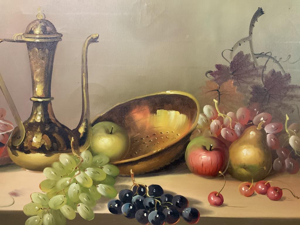 Large Signed Still Life Painting On Canvas: This is a sizable, framed still life painting. The piece is vintage, possibly antique. The piece is set in a gold toned wooden frame. The art depicts fruit, wine, and a bowl atop a table, the table ha