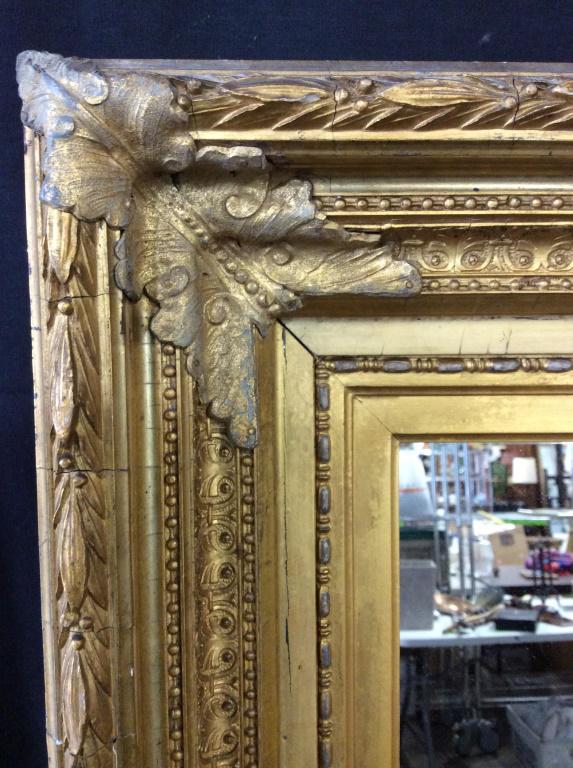 Ornate Multi Tiered Gilt Wall Mirror: Vintage Multi tiered ornate Victorian Gilt frame. Possibly antique. Mirror set back from framing. Ornate detail in relief- scrolls, leaf florals , reticulated dot and line patterns. Frame is possibly