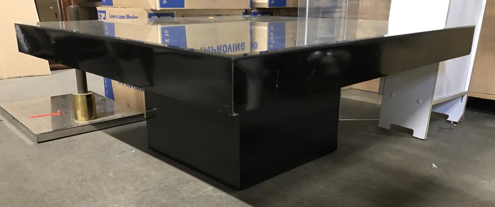 Vintage Square Shaped Glass Top Coffee Table: Coffee Table is black toned. Piece is square shaped. Table top is mirrored. Mirrored surface is Beveled. Coffee table, vintage coffee table, glass top coffee table. Piece has some scratches and wear.