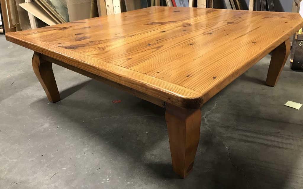 Carved Wooden Rounded Square Shaped Coffee Table: Coffee table is possibly hand crafted. Table is wooden and has square shape with rounded corners. Piece measures approx 54 inches wide & deep, 18 inches tall. Piece has carved wooden legs. Contains 1