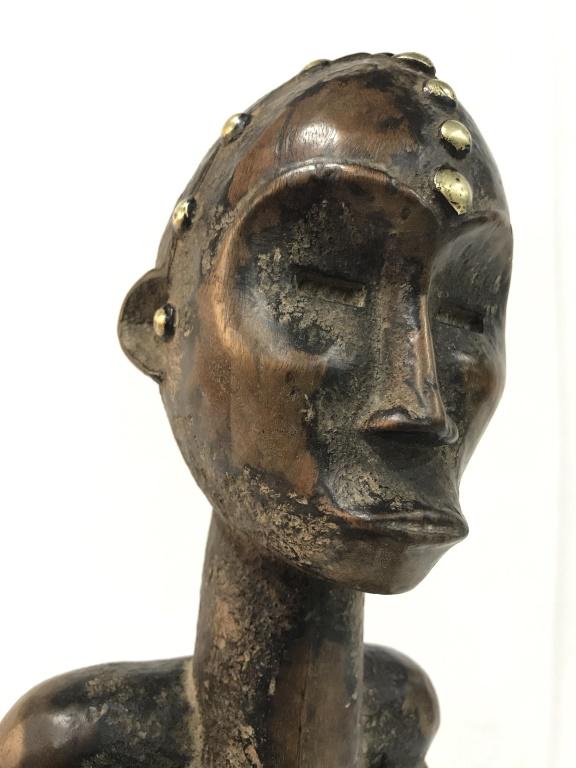 African Art Fang Byeri Figural Reliquary Sculpture: Carved wooden Byeri figural reliquary statue from the Fang People in Gabon, Central Africa. Seated figure has brass metal stud attachments along hairline, forehead, and bellybutton. Figure has hands c