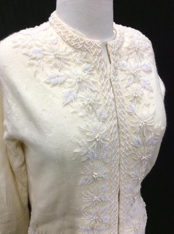 Vintage Hand Beaded Cashmere Sweater: Silk lined cashmere sweater (including sleeves), hand stitched seed beads in reticulated floral pattern with center pearls. Very pale yellow color, hook and loop closure, crew neck. Size small. Sweate