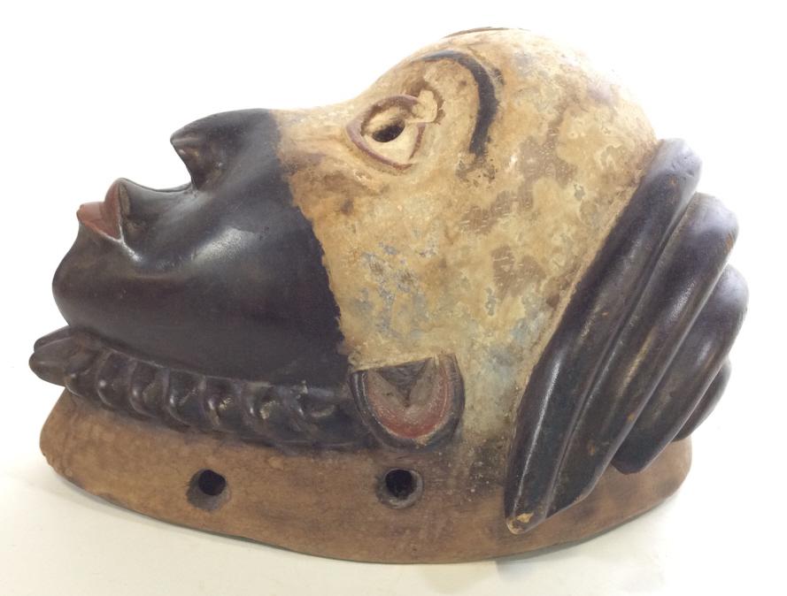 African Punu Art, Performance Mask, Gabon: Hand carved and hollowed wood from tree truck, Tribal PUNU Mask from Gabon in Central Africa. Open Pupils, half Painted with kaolin pigment, pursed red lips and detailed hair cornrows. 12 in long, 10 