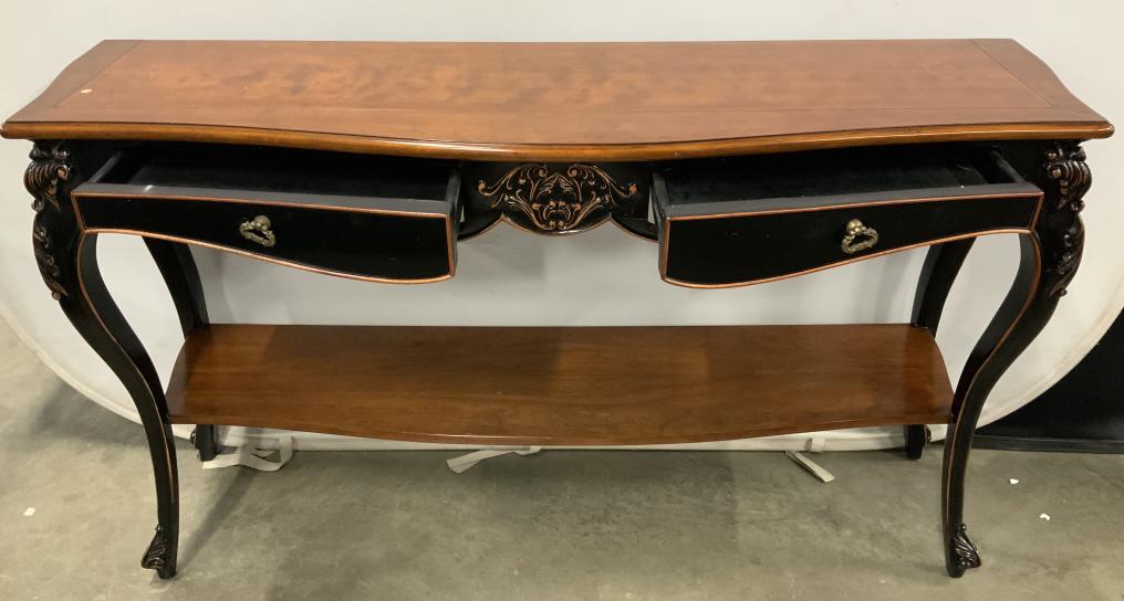 Vintage Cabriole Leg Carved Wooden Console Table: Console table is wooden. Piece has 2 carved wooden cabriolet style legs. Table includes 2 drawers each with gold toned brass handles. Piece is black & light brown toned. Table measures approx 60 inche