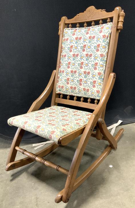 Vintage Floral Detail Carved Wooden Rocking Chair: Rocking chair is wooden. Contains carved detail. Piece is vintage. Upholstery has floral & leaf detail. Piece has double welting at edges of upholstery. Piece measures approximately 36 inches tall 18 