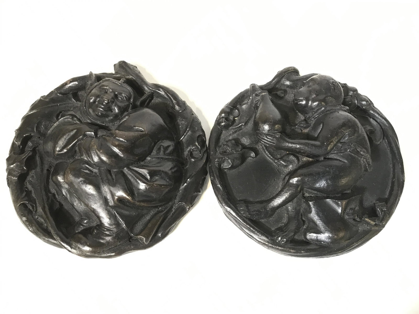Pair Handmade Codestone Medallions: Pair of Handmade Codestone Wall Medallions, 5.5 in. diameter, one of leashed monkey, the other a smiling gnome, each with sticker label on underside reads ‘Handmade in Cambridge England’. Codeston
