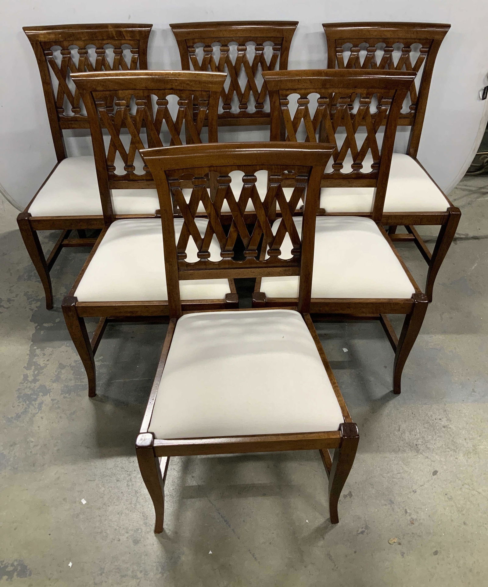 Set 8 Carved Wooden Dining Chairs: Lot includes 8 dining chairs. Dining chairs are wooden with carved x shape pattern detailed backrest. Chairs have white toned seat cushions. Each piece measures approx 39 inches tall 20 inches wide &