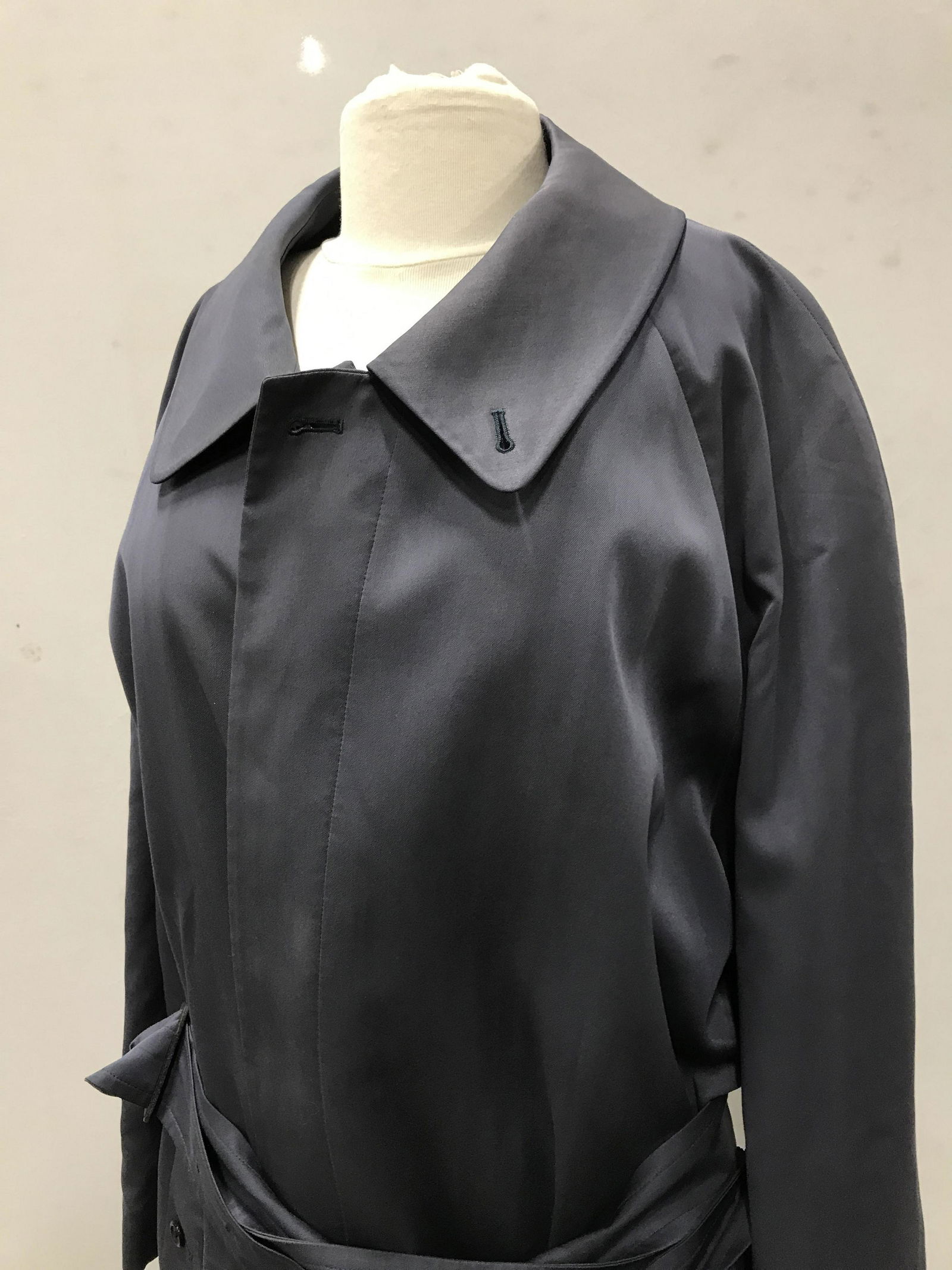 Burberry’s of London Trench Coat w/ Xtra Lining: Made in England. Ladies Trench Coat, Slate Blue, sz 46, length 51 in. Interior Plaid lining (50/50 Cotton & Wool Combo). Side button pockets, backside slit with button, belt, 5 front buttons, ( missin