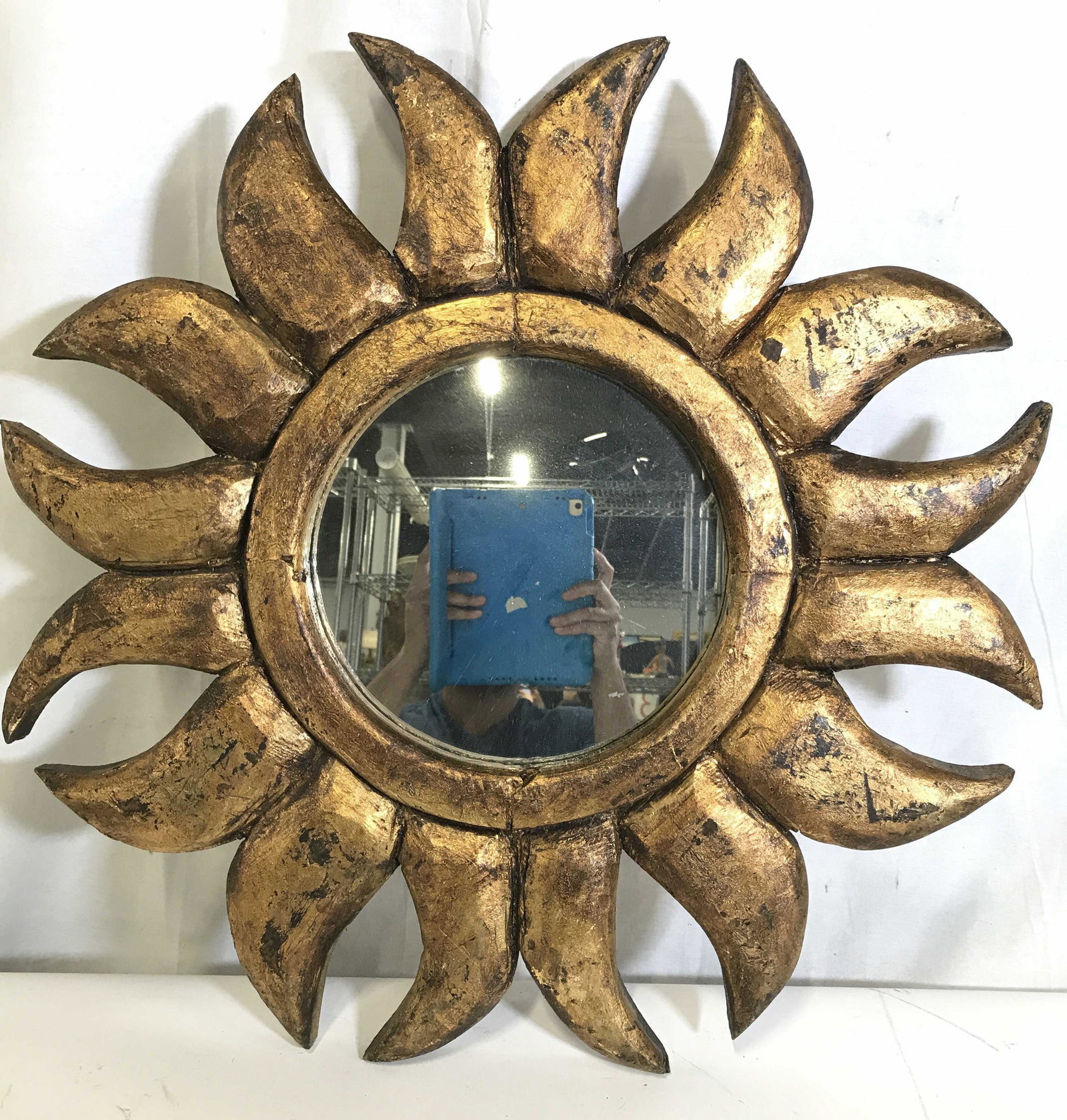 Gold Toned Frame Sunburst Wall Mirror: Wall Mirror has gold toned frame. Piece has Sunburst style frame. Frame appears to be wooden. Frame is gold toned, appears to possibly be gold leafed. Mirrored surface is circular. Piece measures appr