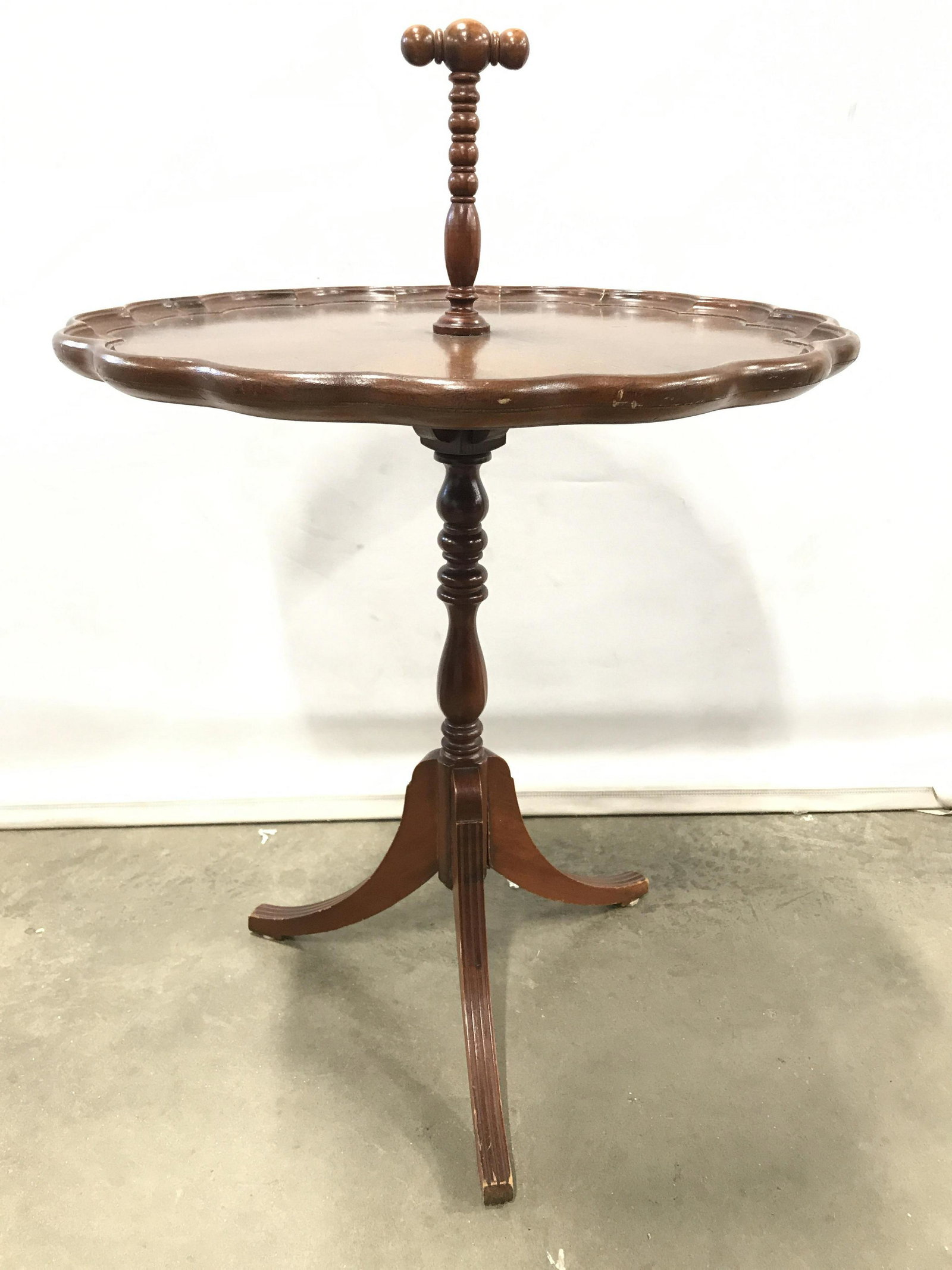 Vintage Carved Wooden Pie Crust Table W Handle: Table is wooden. Piece has tripod style structure near base. Piece has piece crust edges. Table has carved wooden handle in center of table top. Pie crust table, pie table, vintage table, vintage wood