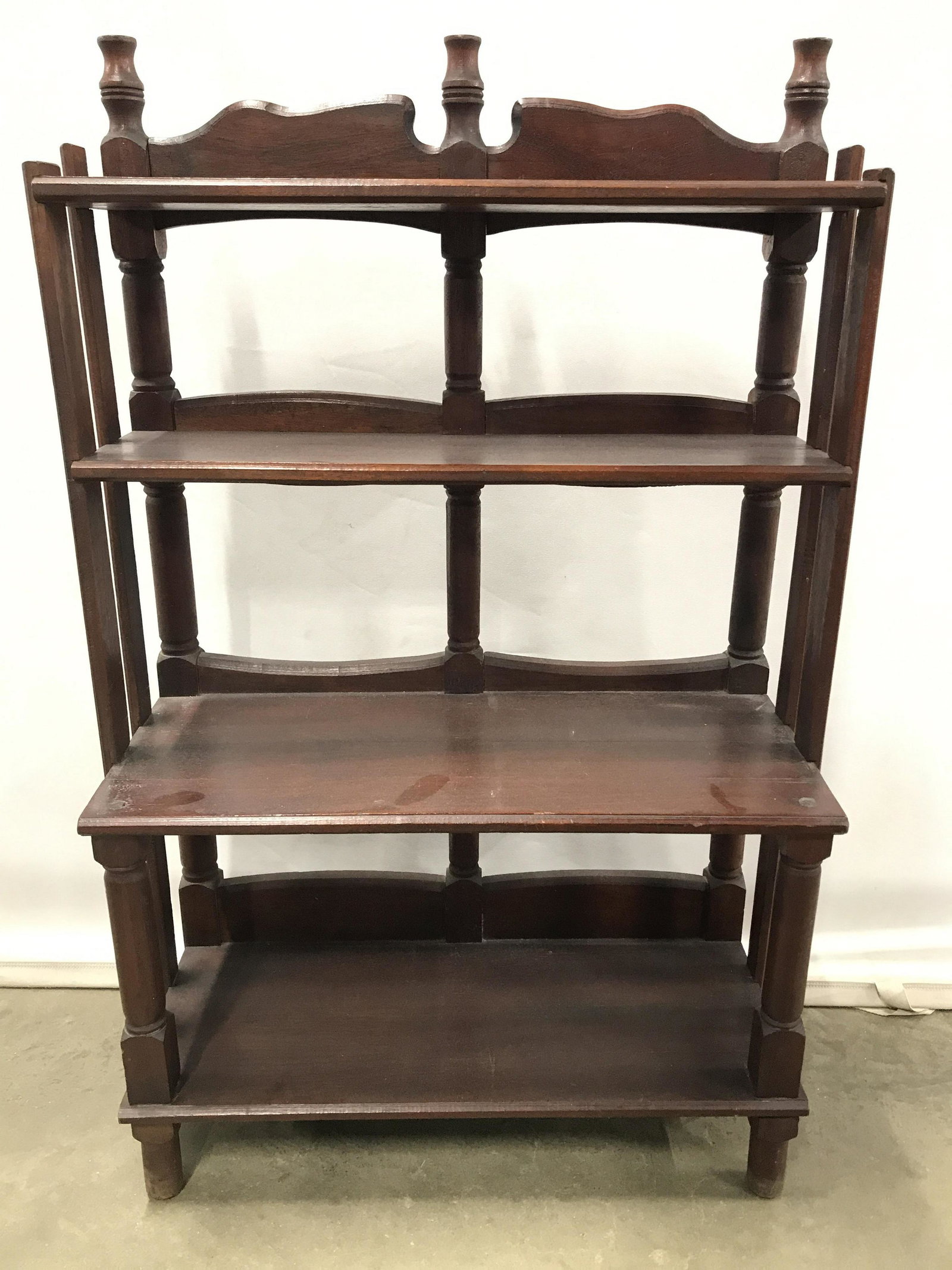Vintage Carved Wooden Display Shelves: Display shelves are wooden possibly mahogany. Piece is vintage possibly antique. Piece has 4 tiers including top & bottom. Piece has 3 carved finial like structures at top. Piece measures approximatel