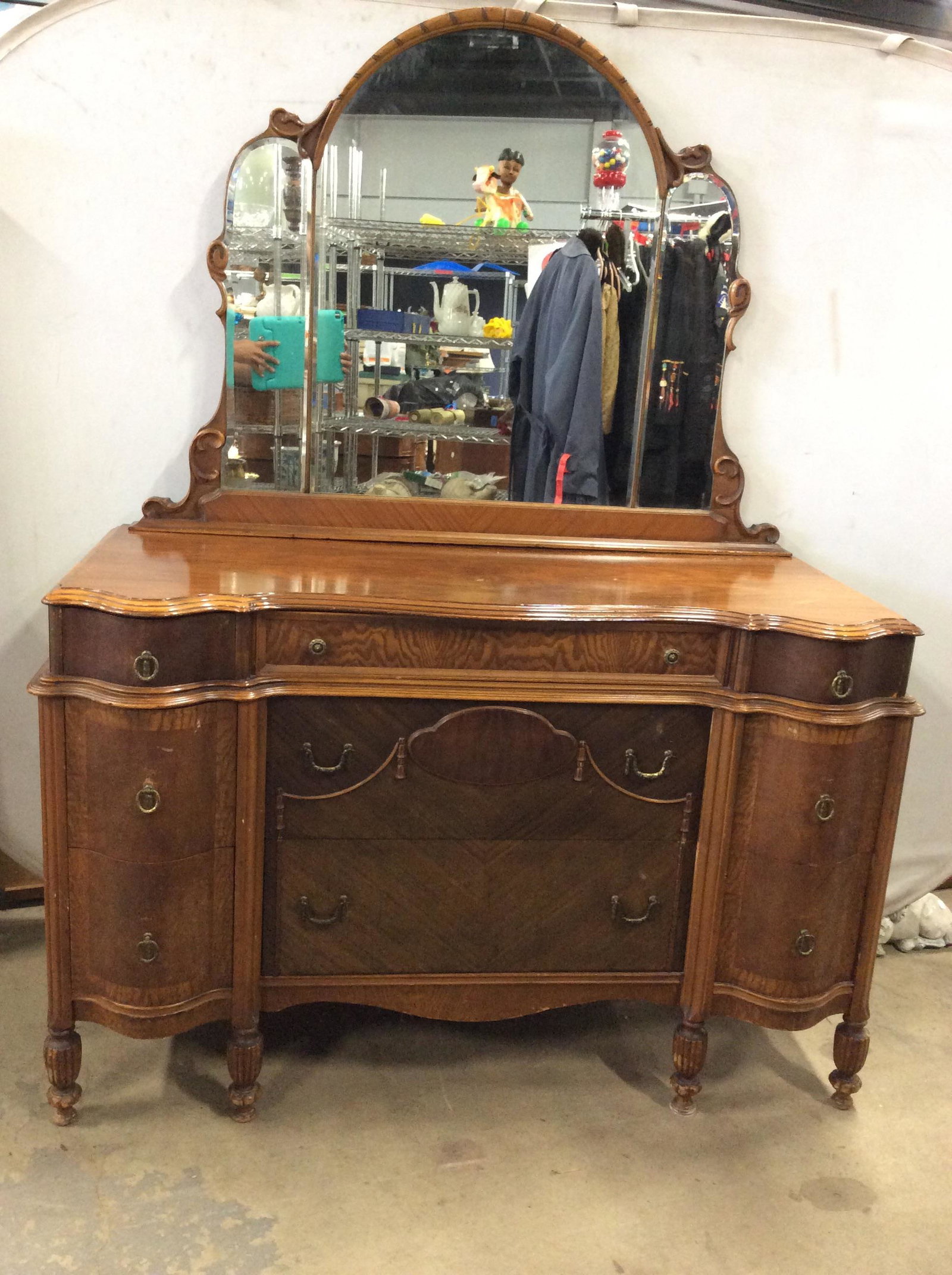 Antique GETTYSBURG FURNITURE Vanity Dresser: Vanity Dresser has tag which reads GETTYSBURG FURNITURE COMPANY. Piece has 3 panel mirror on top with intricately carved wooden frame. Piece has 9 drawers. Some drawers have gold toned brass loop styl