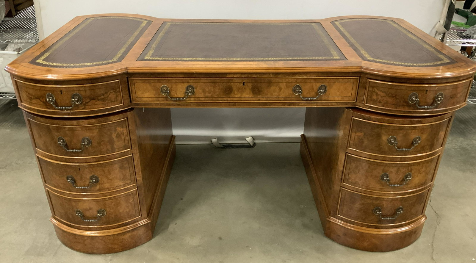 Vintage Leather Topped Partners Desk: This is a vintage partners desk, the piece is leather topped. The leather sports gold detailing around its edges. The desk is finished in a walnut burl veneer. The piece measures approx 32 inches H, 6
