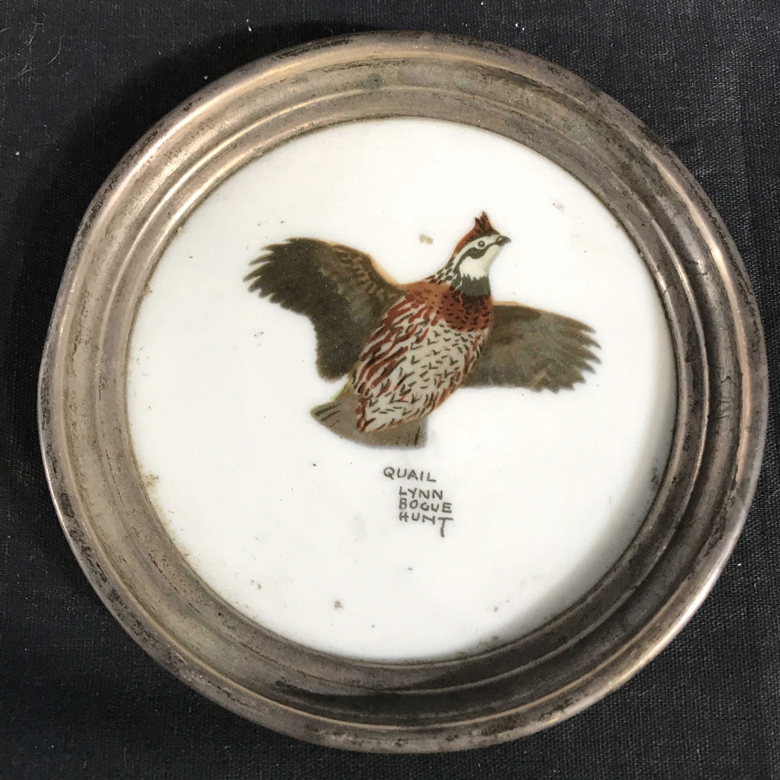 Lot 4 Painted Bird Coasters: Lot includes 4 coasters. 2 Coasters are signed LYNN BOGUE HUNT 2 are marked FRANK M WHITING on undersides. Pieces includes Canada goose, quail, bobwhite quail and pheasant. Each have silver toned rims