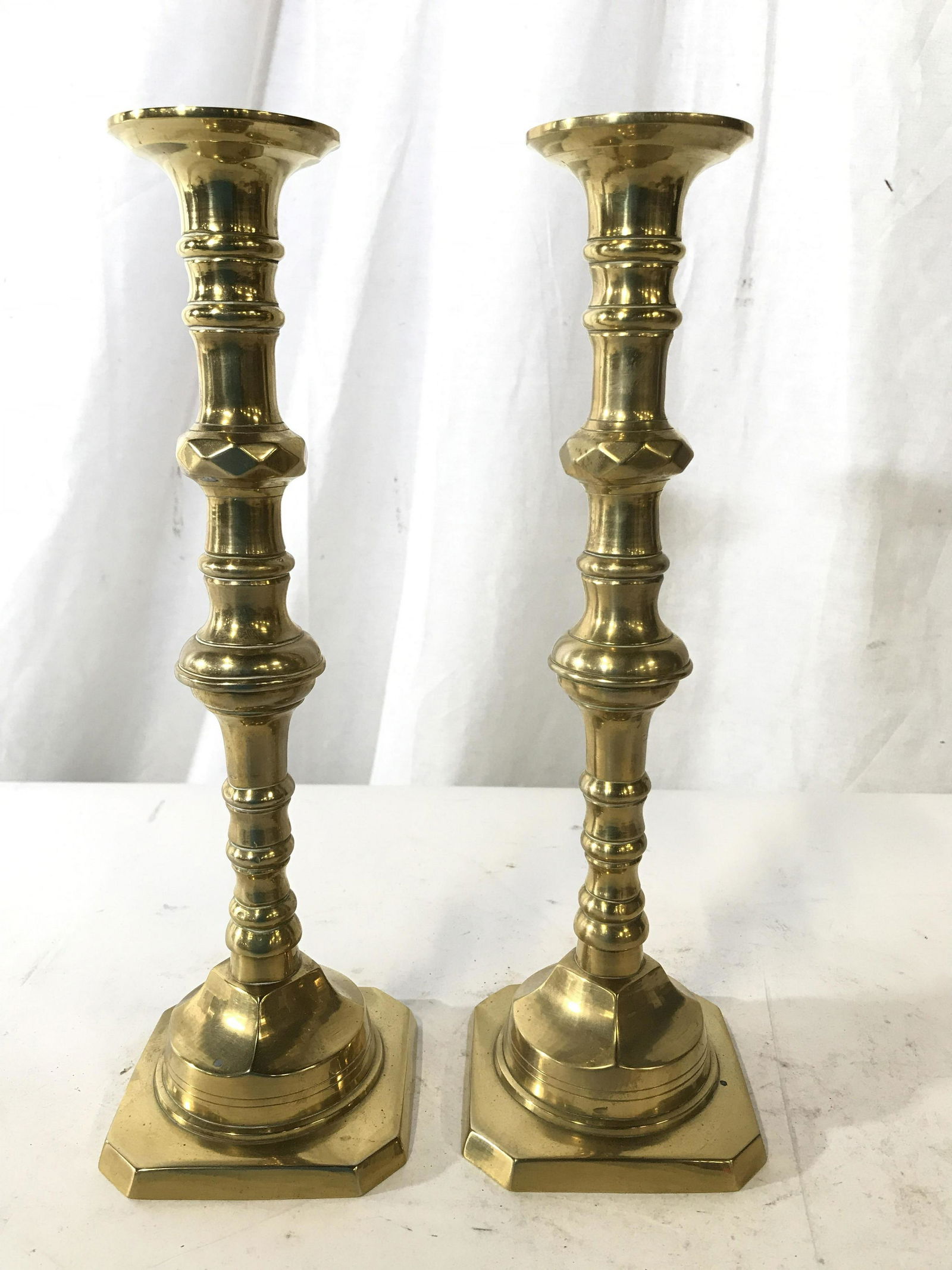 Vintage Pair Gold Toned Brass Candlesticks: Lot includes 2 gold toned brass Candlesticks. Each measures approx 12 inches tall 4 inches wide and deep. Brass Candlesticks, gold Toned Candlesticks, dining table accessories, tabletop accessories. E