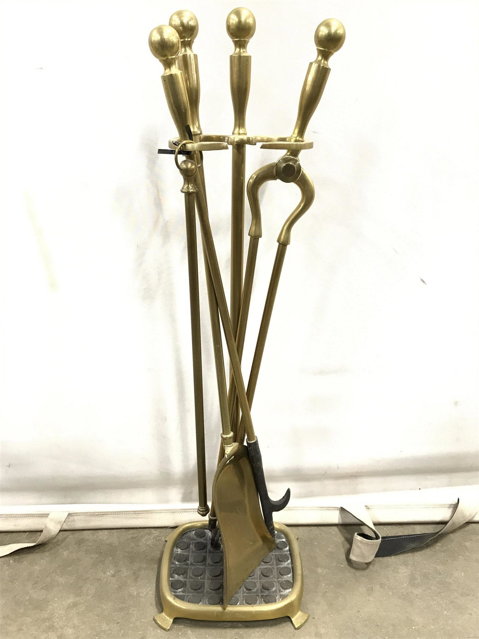 Set 5 Gold Toned Brass Fireplace Tools: Lot includes stand, poker, shovel, grabber & broom handle. Pieces are gold toned and brass. Tool Stand is footed. Stand measures approximately 28 inches tall 8 inches wide 7 inches deep. Each piece ha