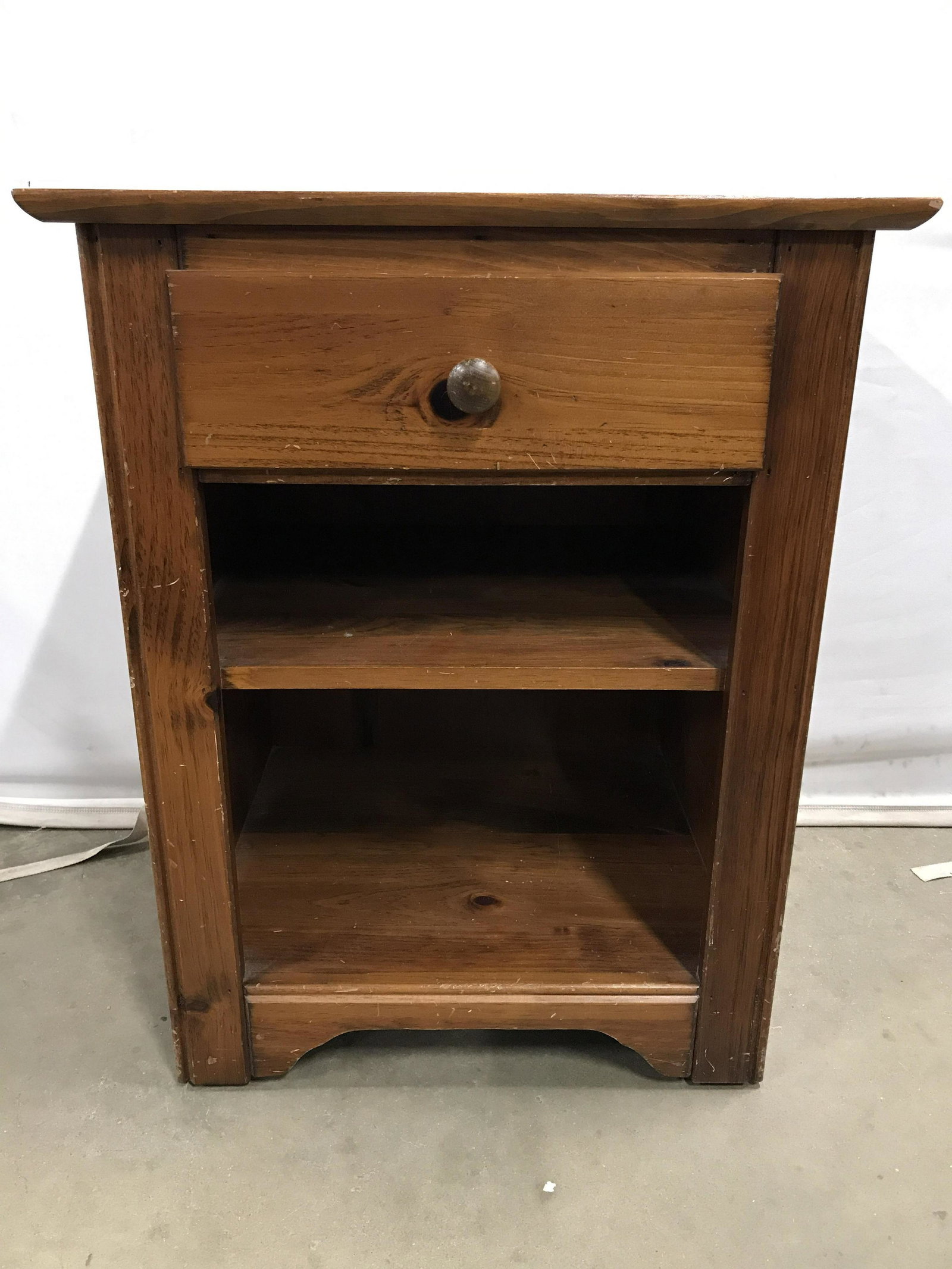 Vintage Carved Wooden Nightstand: Nightstand is wooden. Piece has 1 drawer with knob style handle. Piece has 1 shelf. Drawer appears to have hand dovetailing. Nightstand, wooden nightstand, vintage nightstand, vintage wooden nightstan