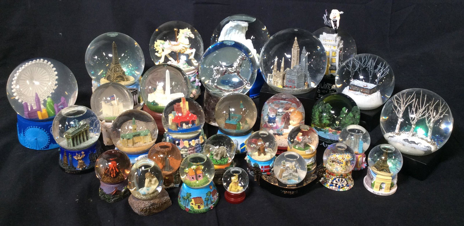 Lot of 29 Snowglobes: Lot of 29 collectible Snowglobes featuring various around-the-globe landmarks such as Venice, Berlin, London, Costa Rica, Hamburg, Aspen, and New York City. Three snowglobes are also music boxes. Rang