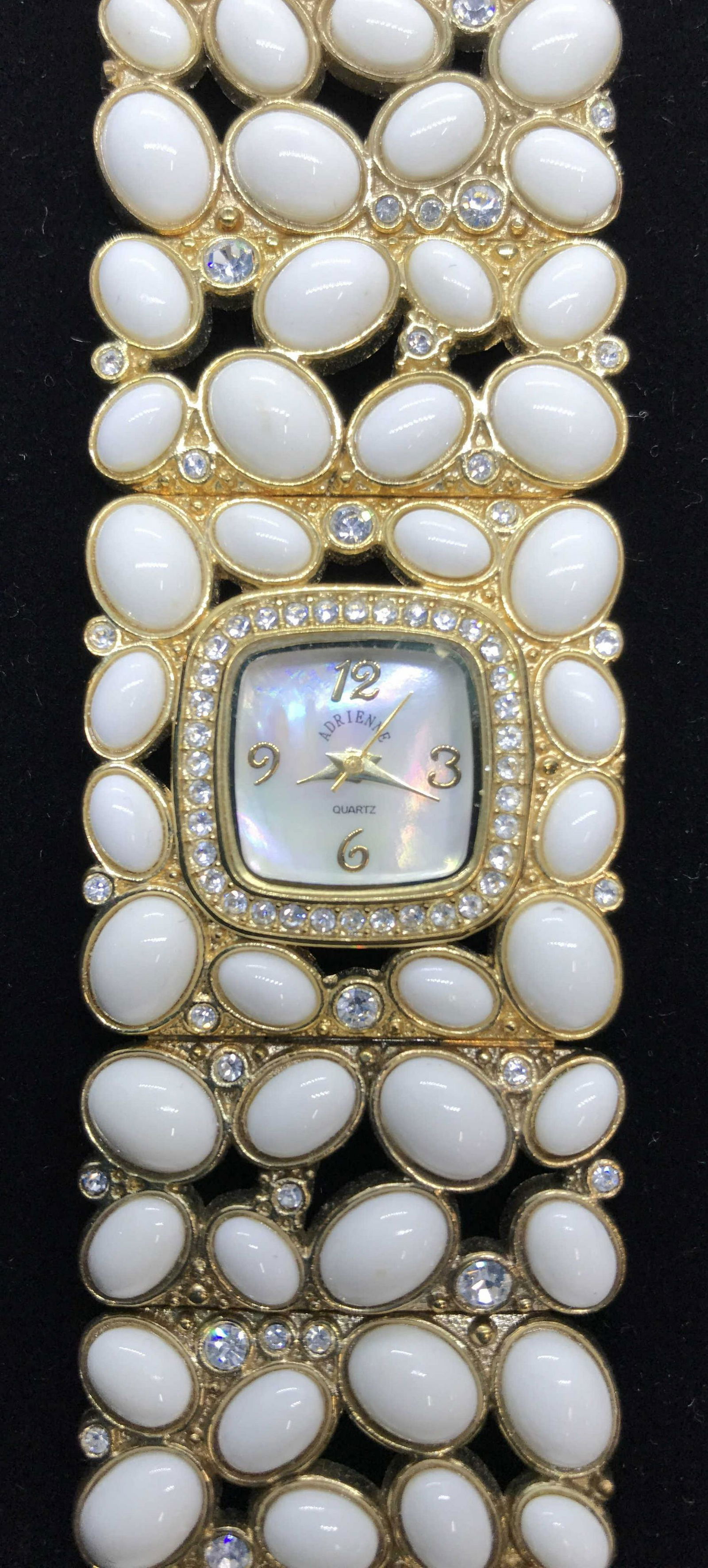 Adrienne Vittadini MOP, Crystal & Bead Watch: Pierced Bance design with Egg shape white cabochons & crystals on gold tone metal. Hook latch, watch face Mother Of Pearl. Labeled Adrienne, front & verso. Stainless steel back with Japan Movement Mec