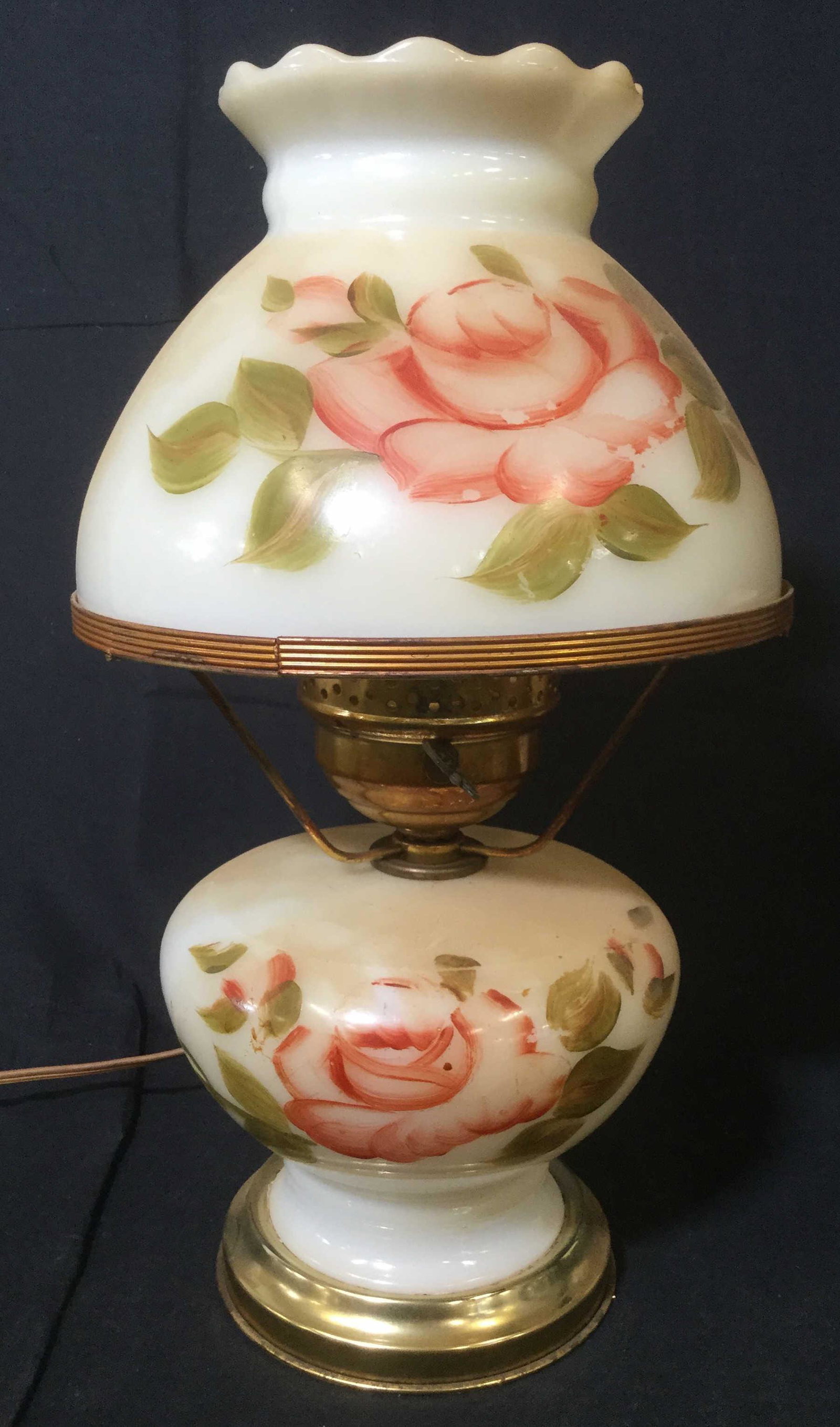 Vintage Hand Painted Tabletop Lamp: This piece is a hand painted vintage, possibly antique, tabletop lamp. The piece is constructed from glass and brass. The body and lamp shade have been painted to depict flowers. There is some wear pr