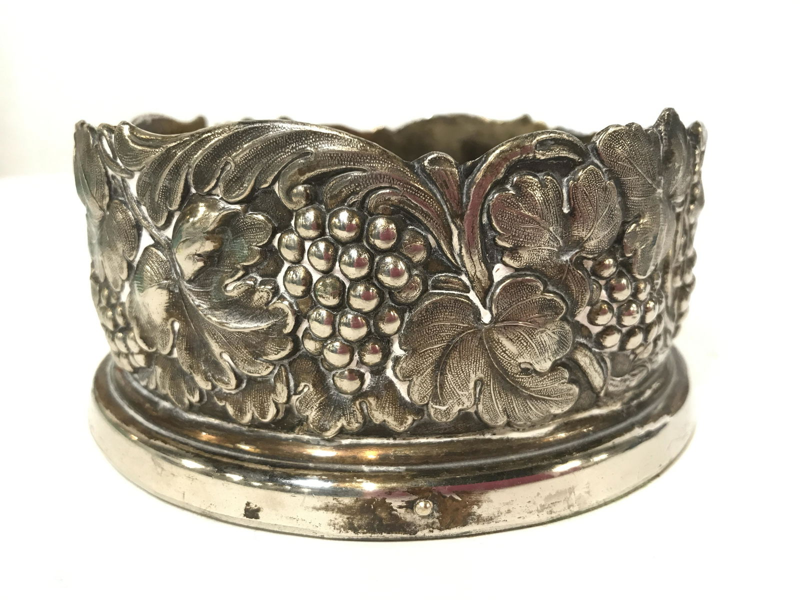 Vintage Silver Plate Champagne Wine Bottle Coaster: Vintage possible silver plate over copper Champagne Wine Bottle Coaster With Grape and Vine raised design, interior wooden coaster and green felt underside, some wear to silverplate, scratches to wood