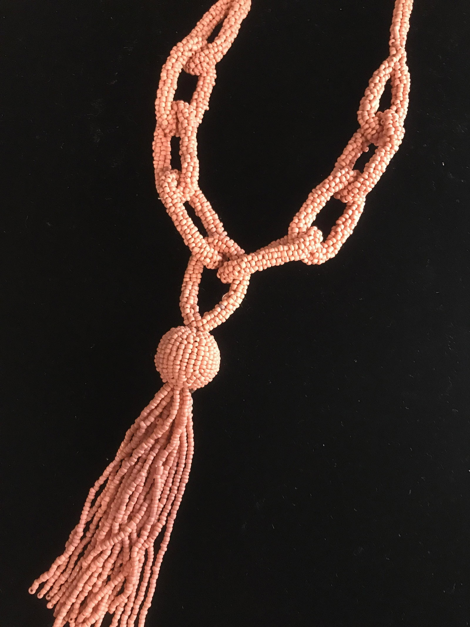 Chain Design Micro-bead Tassel Necklace: Hangs app 21 in. Necklace opening measures app 21 in. long. Peach/ coral hue seed beads, hand strung, form chain link design, long dangle tassel. Beaded Necklace, Chain Link Design Necklace, Seed Bead