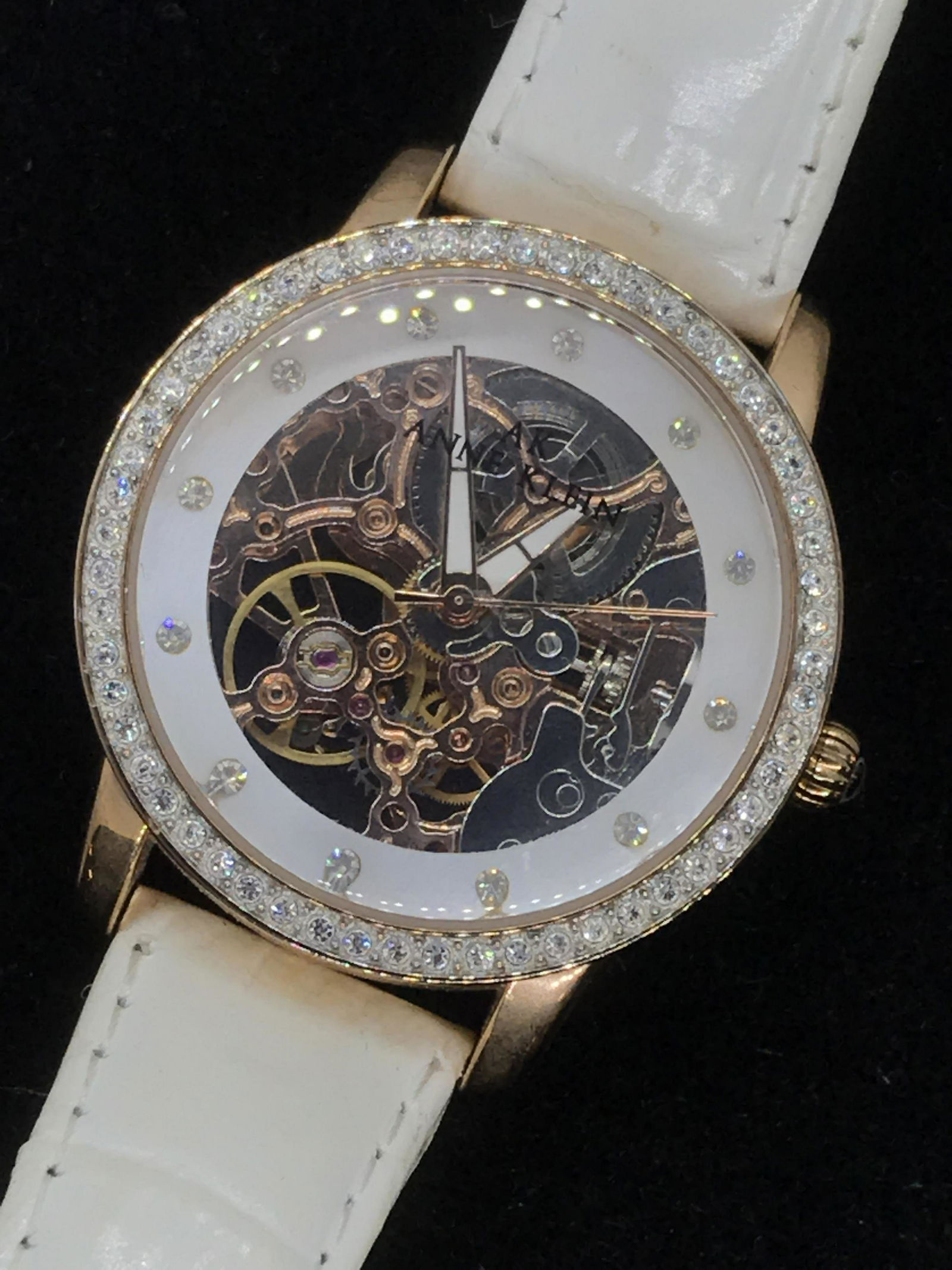 Anne Klein Industrial Rhinestone Wristwatch: Clear glass face wristwatch by designer Anne Klein. Shows Internal watch mechanism. Watch face app 1.5 in. halo of rhinestones. Backside reads ‘Japan movement Water resistant, 100 FT, Base Metal Bez