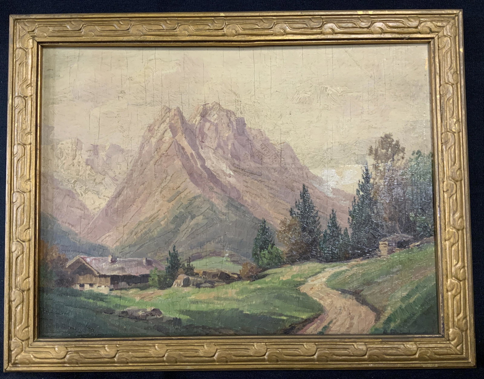 Signed Oil on Wood Painting: Oil on wood painting, landscape of mountains and cottage, some cracks to paint, warm sunset color palette, painterly style, signature painted in lower right corner covered by frame, some tap to revers