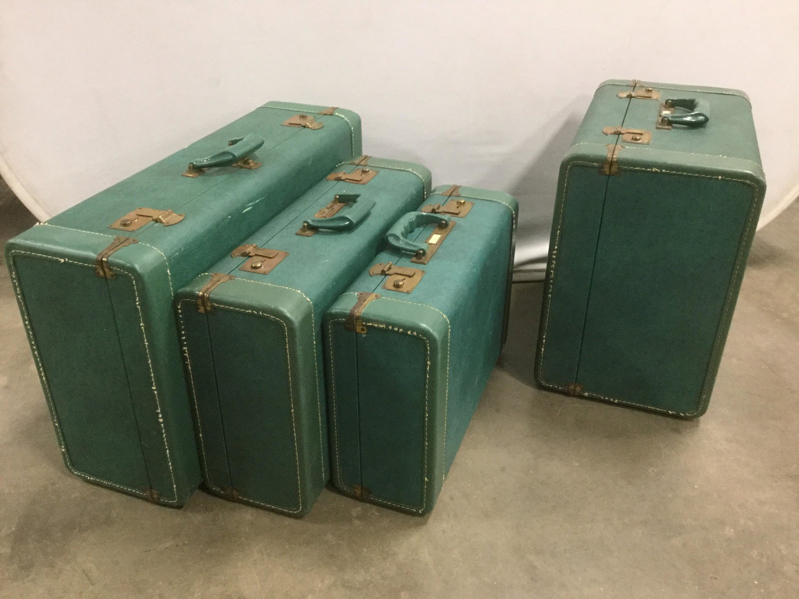 Set 4 Vintage CROWN LUGGAGE CO. Suitcases: This is a set of four vintage suitcases. They are all from CROWN LUGGAGE CO. The cases are vintage, and are colored in teal tones. The clasps, address plates, hinges and feet are all crafted from bras
