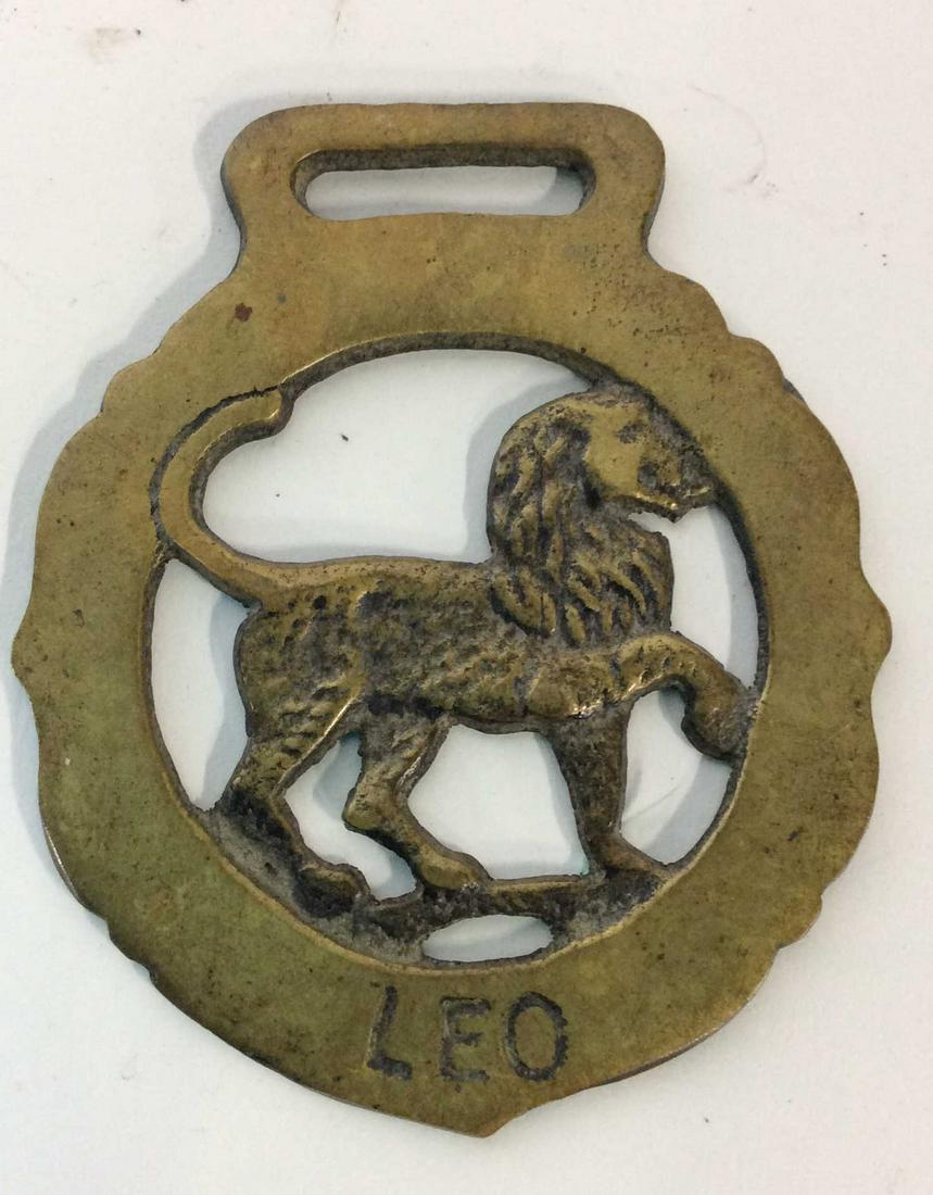 Decorative Brass Toned Leo Medallion: Brass toned Medallion with Leo inscribed. Lion in middle of Medallion. Measures approx 2.5 inches diameter. Flat on one side. Medallion, Decorative, Accessory, Decorative Accessories, Brass Toned, Lio