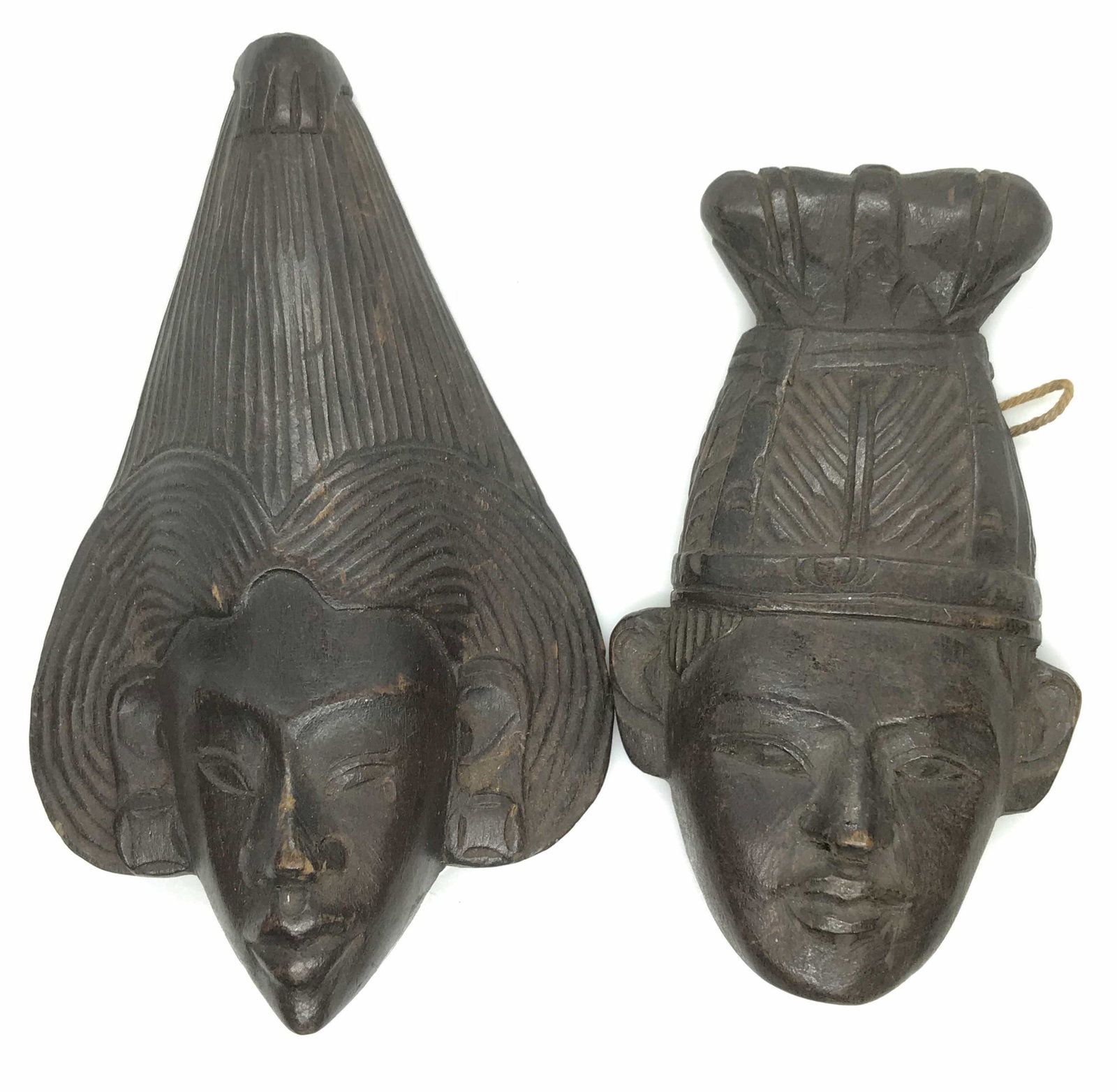 Set 4 Carved Tribal Face Figurals: Dark mahogany color wood faces, 1 Pr made in Indonesia. Green Sticker on one reads ‘Made In Indonesia’. App size 4 x 2.5 in. String attached to hang on wall. 1 Pr Very dark mahogany color ,backsid