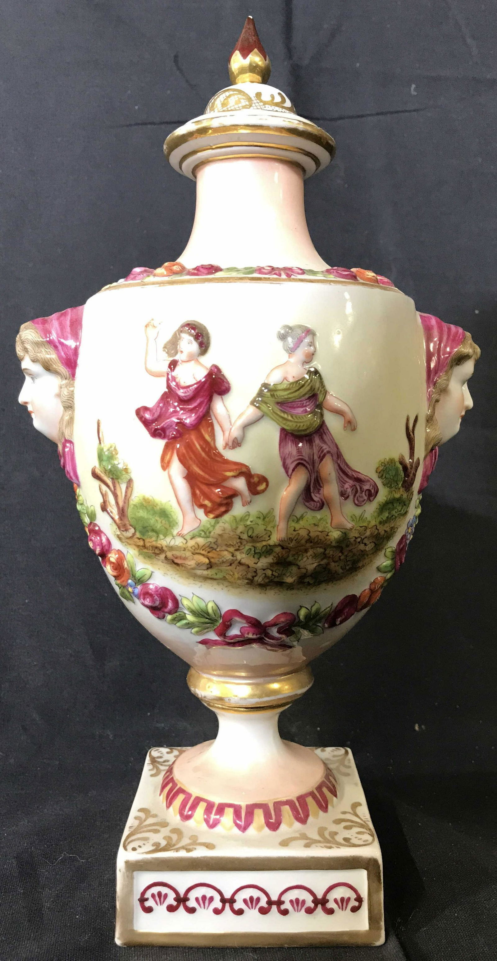 Vintage Porcelain CAPODIMONTE Urn: Urn has trademark on underside. Piece includes lid. Urn is Pedestaled. Piece appears to be hand painted with detail depicting multiple figures. Each piece measures approximately 10.5 inches tall 5.5 i