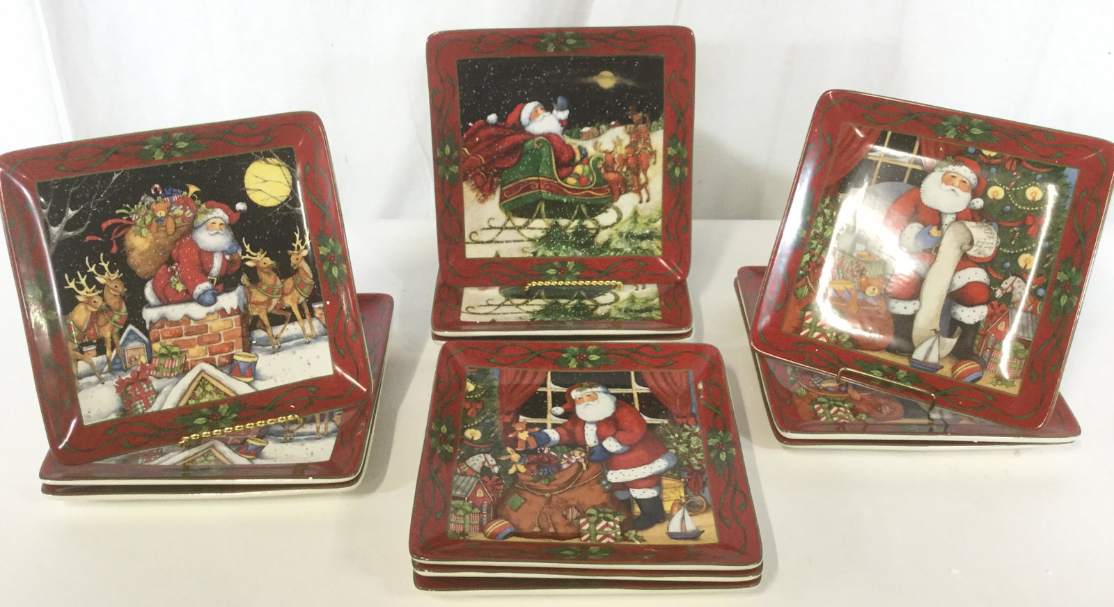 Lot 12 Santa Claus Holiday Plates: This lot includes 12 Santa Claus plates. There are four different illustrations, three plates per illustration. Underside reads CERTIFIED INTERNATIONAL. The plates measures approx 10.5 inches by 10.5 