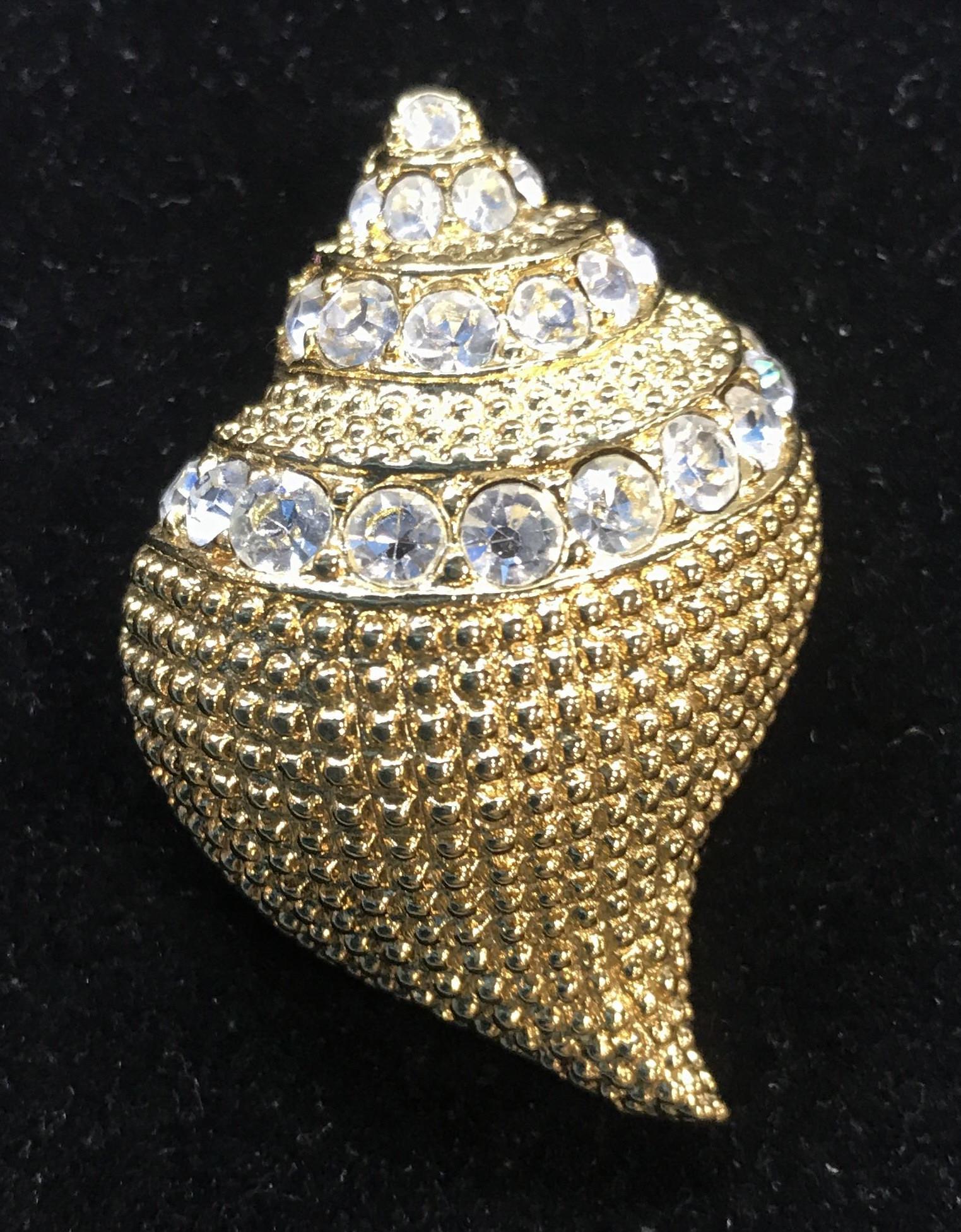 Signed Kenneth Jay Lane GoldTn Shell Pin: Signed KLJ brooch, App 1.5 in. long, 1.25 in. wide with 3 rows of clear rhinestones accented with top stone. Embossed stud pattern metal. Luxe Designer, KJL Jewelry, Signed KJL Gold Tone Studded Pin, 