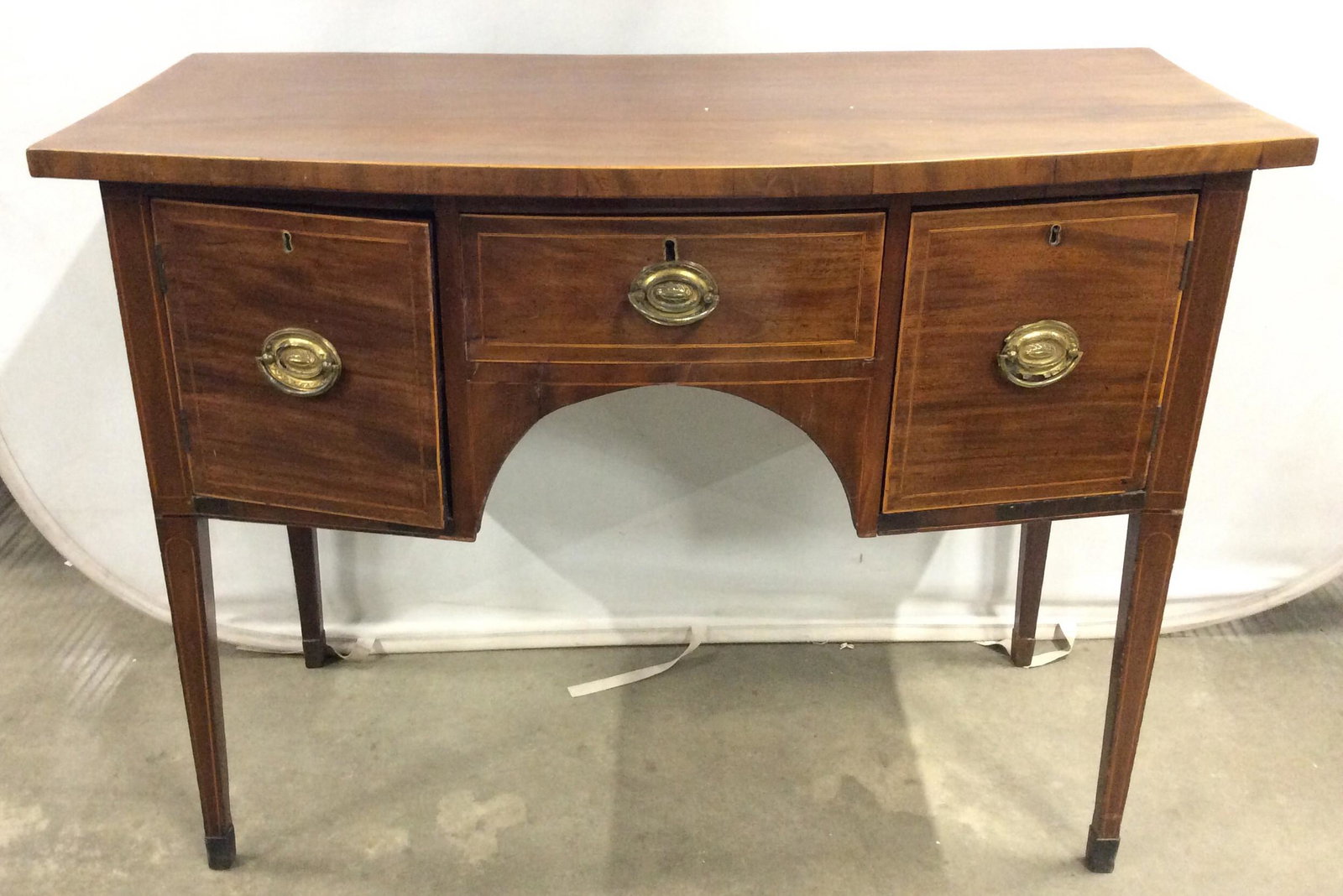 Antique Federal Style Sideboard w Inlay: Writers desk is wooden. Piece is antique circa 1700’s. Piece appears to have hand dovetailing and other handmade elements. Writers desk has 4 drawers each with 2 gold toned brass handles. Desk also 