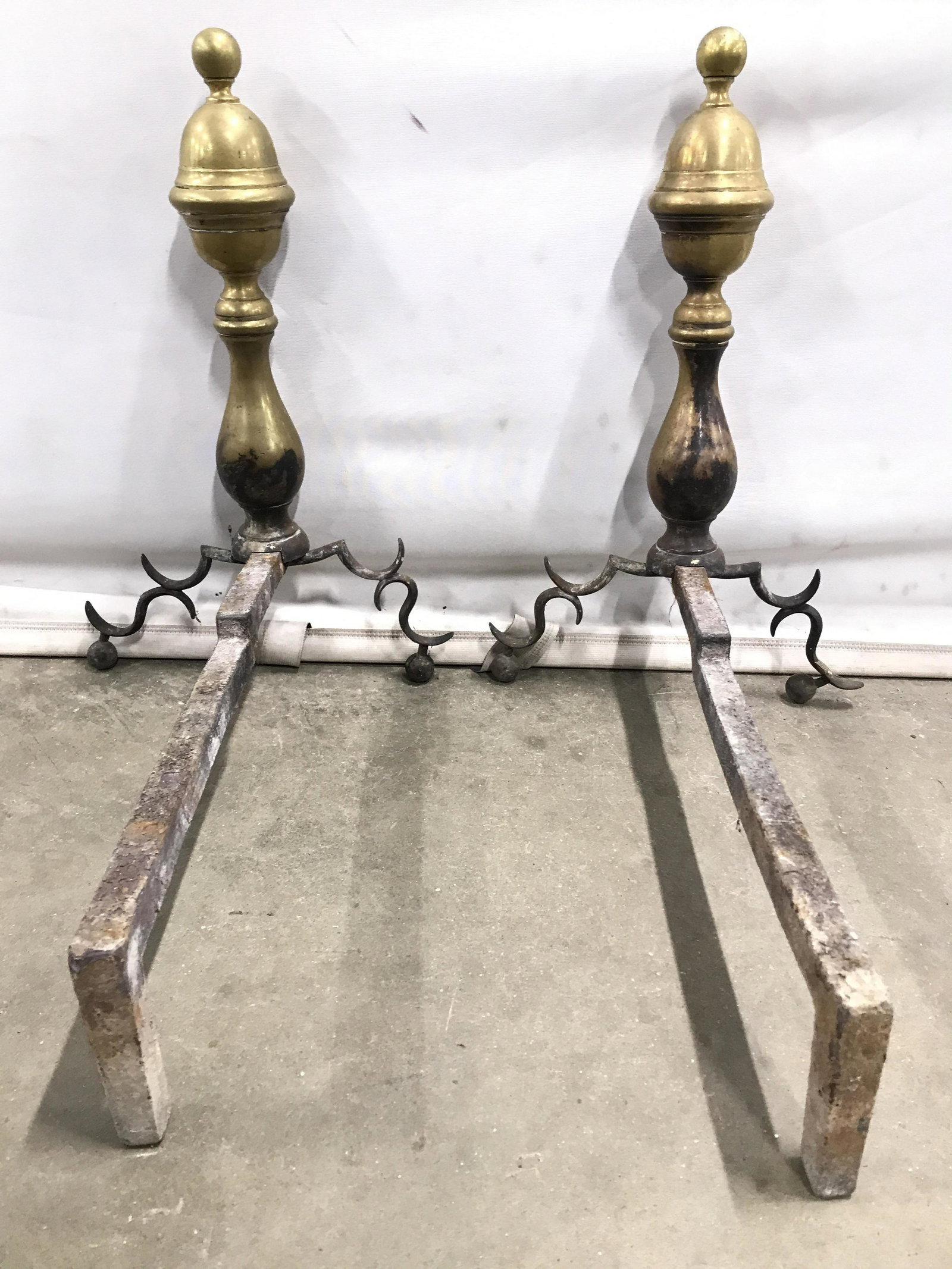 Pair Vintage Gold Toned Andirons: Lot includes 2 Andirons. Each are gold toned and brass. Andirons, Pair Andirons, Brass Andirons, Vintage Andirons, Vintage Brass Andirons. Each measures approx 17 inches tall 18 inches deep 10 inches 