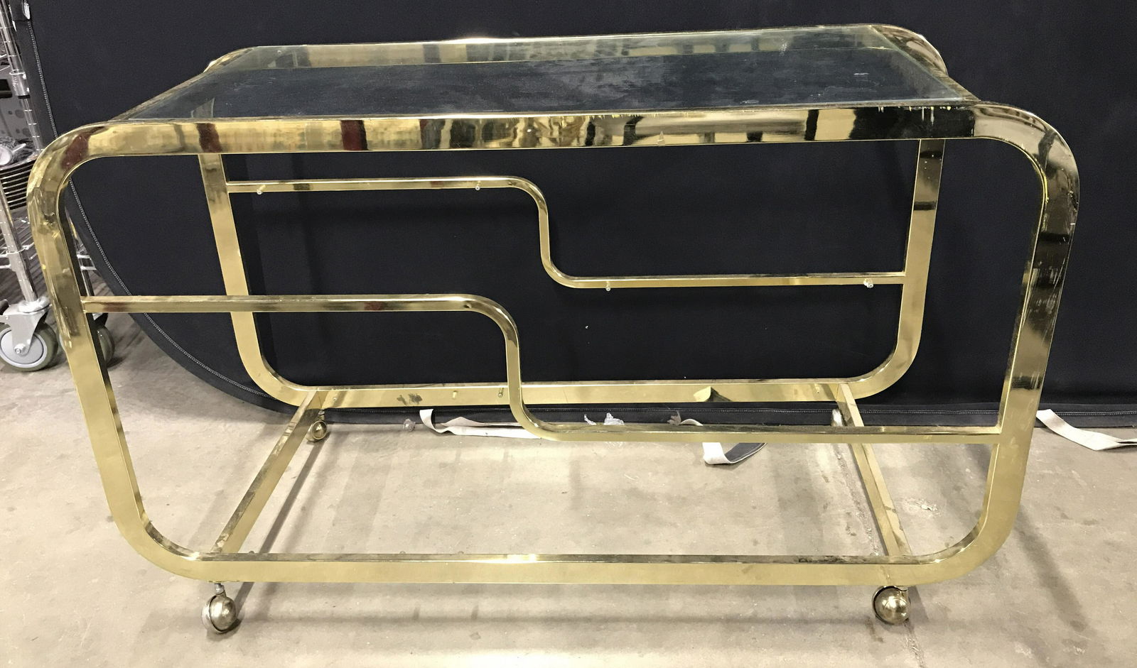 Vintage Gold Toned Metal Glass Top Bar Cart: Bar cart is gold toned and metal. Piece has glass top. Cart has multiple tiers. Bar cart has 4 wheels. Bar cart, beverage cart, tea cart. drinks cart, industriqal design, art deco inspired, Piece meas
