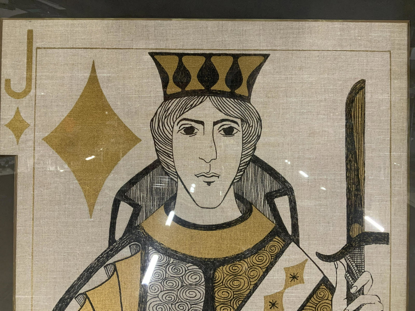 Oversized Playing Card Print on Linen: Oversized playing card print on linen, printed in only black and gold, playing card depicts the Jack of Diamonds, spirals and diamond patterns adorn the sleeves and robes of the figure, the subject ta