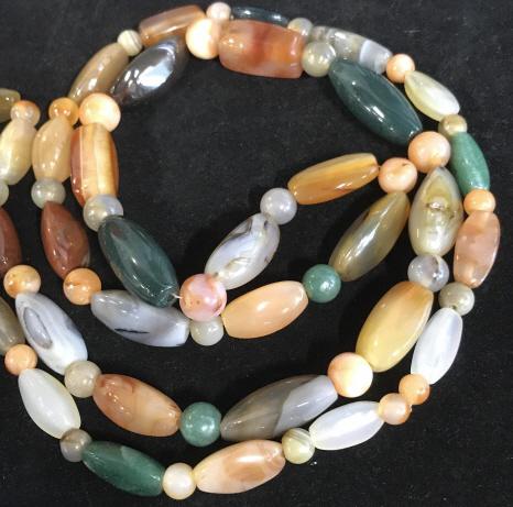Vintage Natural Stone 44 in. Bead Necklace: Polished natural stone necklace. Has weight. Consists of various quartz, chalcedony, agate of hunter green, orange and translucent colored stones. Hangs app 21 in. Avg. size of stones are 1 in. long,