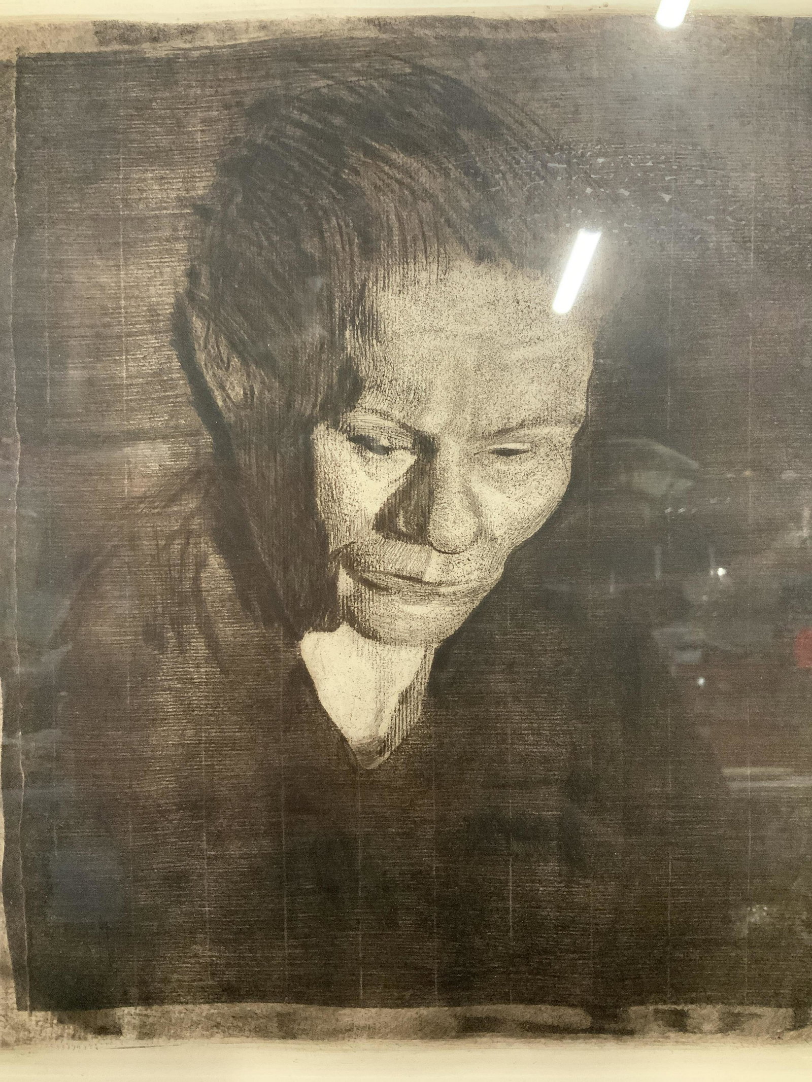 Etching of a Woman AFTER Kathe Kollwitz: Etching of a Woman on heavy weight paper, monotone color palette, subject woman facing downward, white matting, stamp in lower right corner of etching possibly reads Munich, wooden frame, AFTER Käthe