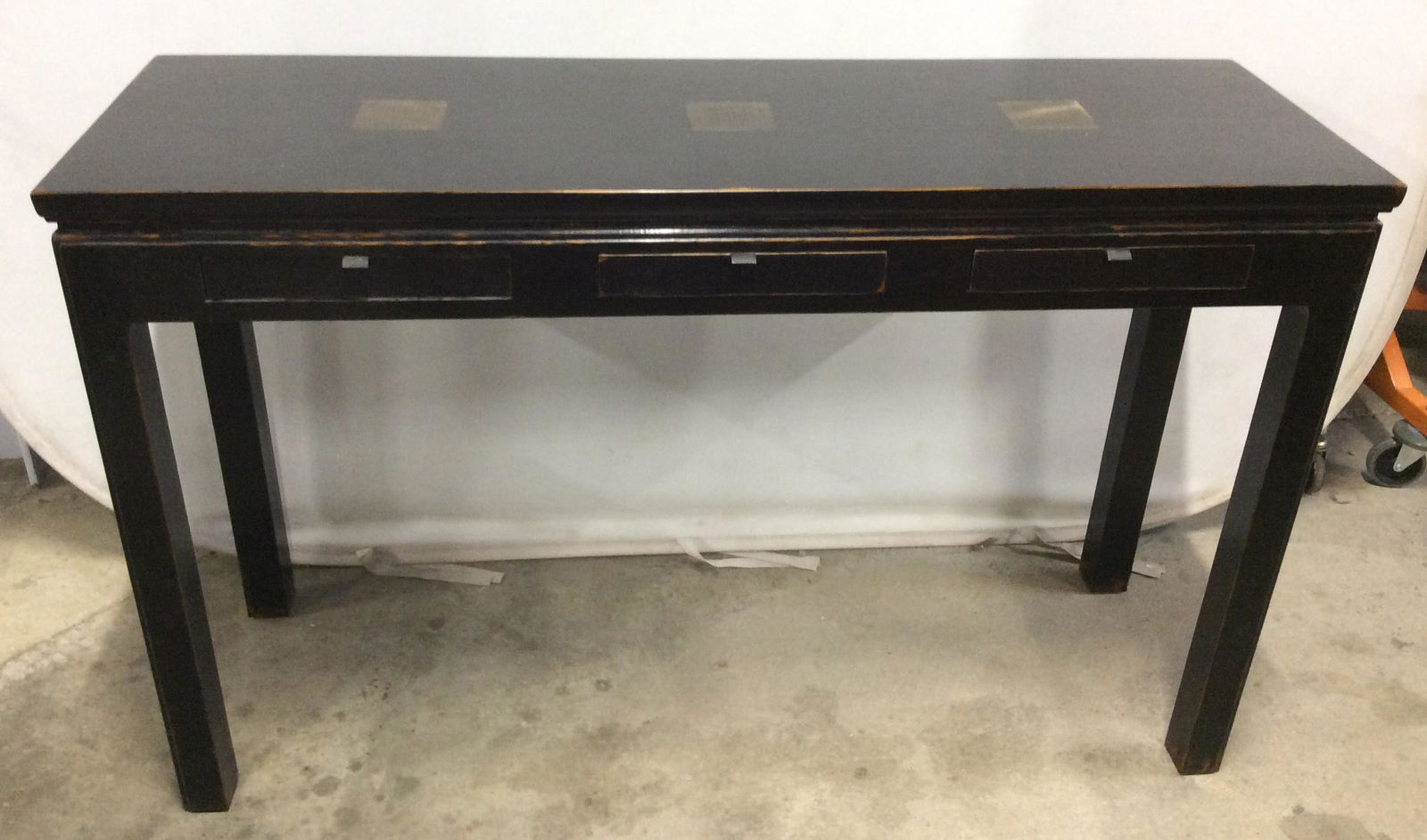 Vintage Asian Console Table w Bronze Inlay: This Console table is vintage, possibly antique. The piece has been colored black. Three drawers are present on the piece, the drawers can be accessed from either side of the table, brass handles are
