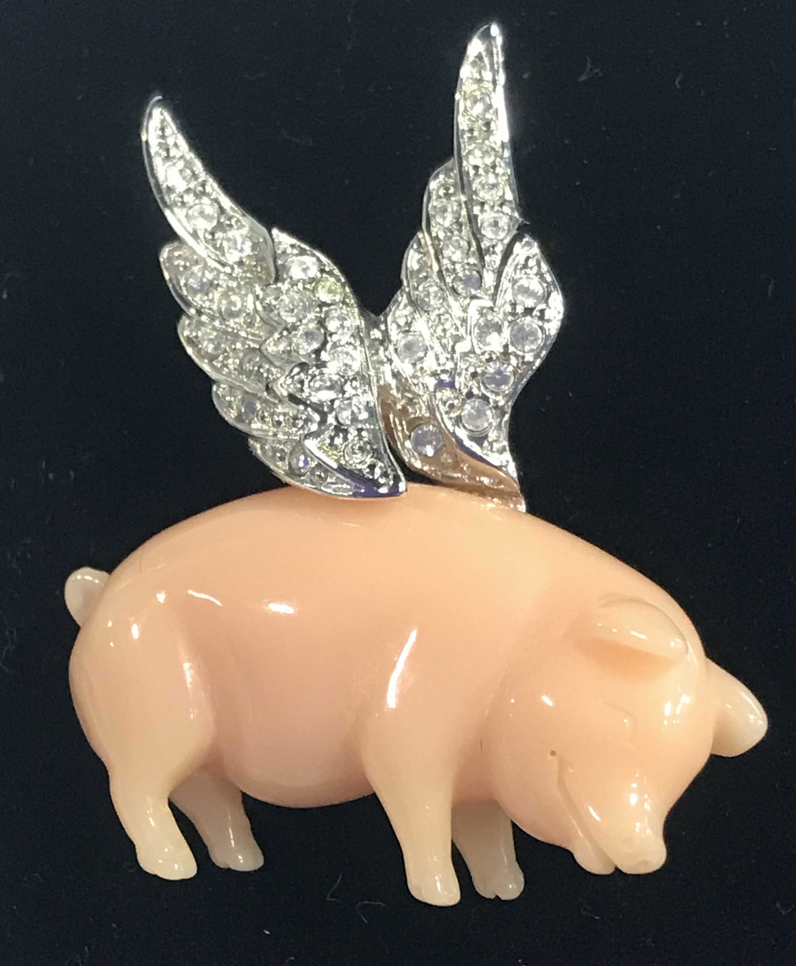 Flying Pig Brooch, Kenneth Jay Lane, Signed: this piece from luxury designer KJL has clear rhinestone decorated wings, pink piggy resin, signed underside on plaque KJL. 1.5 in. tall & wide. Property of Upper East Side Estate. Kenneth Jay Lane Je