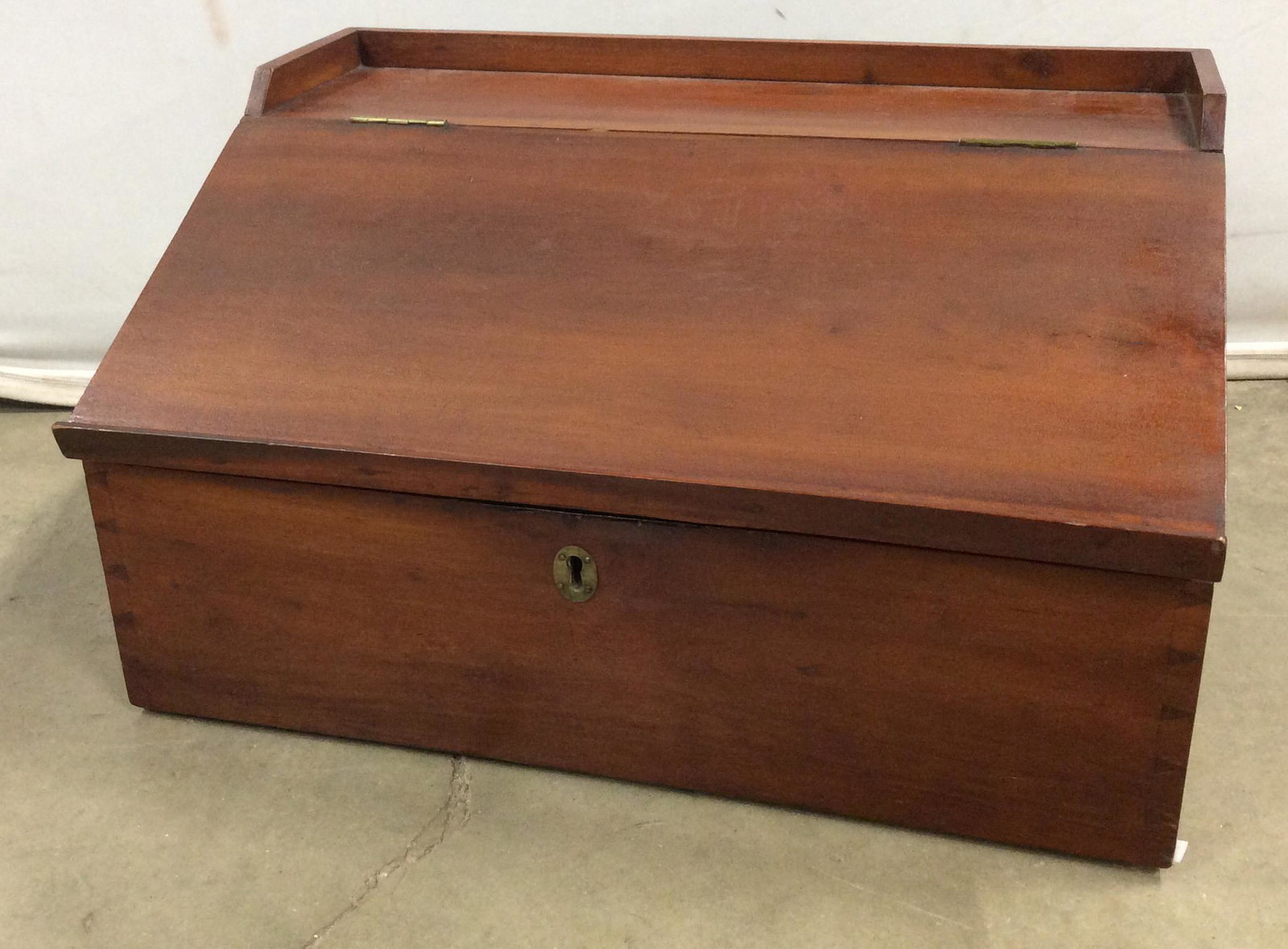 Antique Apothecary Writing Desk: This is a vintage Apothecary writing desk. The Hinged Desktop opens to reveal a number of cubbies and drawers, used for storage. The drawers and cubbies are labeled. A lock is present on the piece, th
