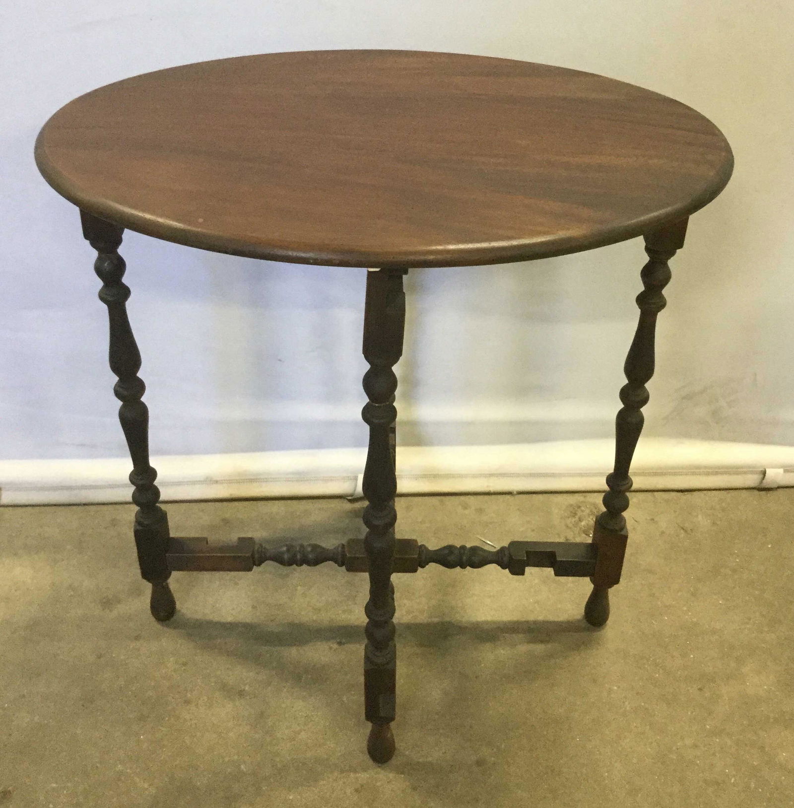 Vintage Mahogany Toned Foldable Oval Side Table: Vintage Mahogany Toned Wooden Foldable Oval Shaped Side Table with turned legs, measures approximately 24 inches long x 18 inches wide x 25 inches tall. Some minor surface scratches, one hinge needs r